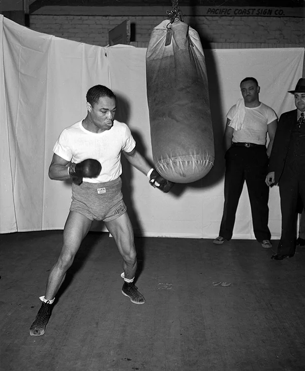 Henry Armstrong trains with a punching bag.