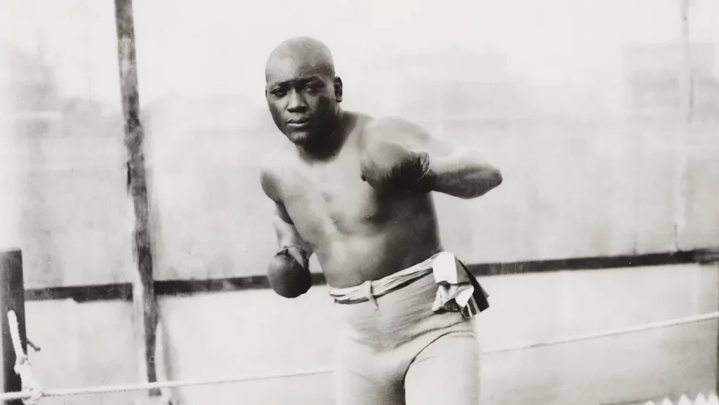 Jack Johnson "The Galveston Giant", doing a boxing pose on the ring.