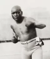 Jack Johnson "The Galveston Giant", doing a boxing pose on the ring.
