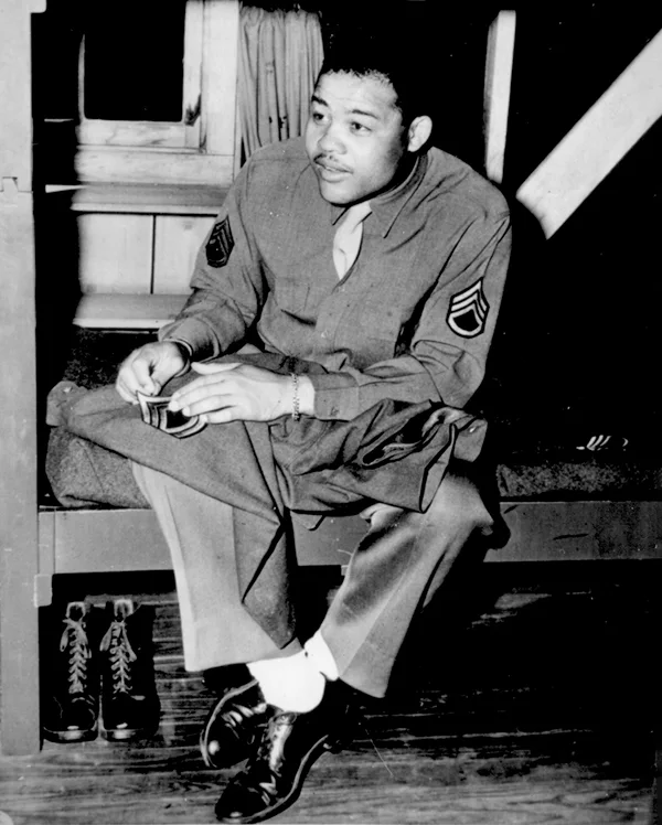 World Heavyweight champ Joseph Louis Barrow (aka Joe Louis) sews on the stripes of a technical sergeant--to which he has been promoted